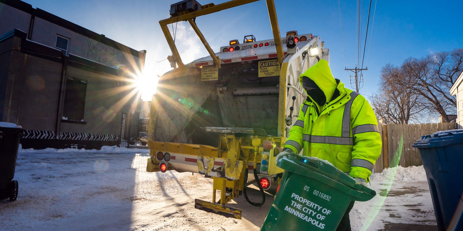 Public works emptying organics container in winter