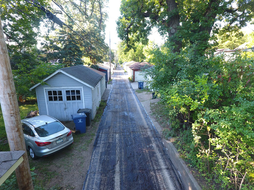 Alley with a garage and trees on either side of it