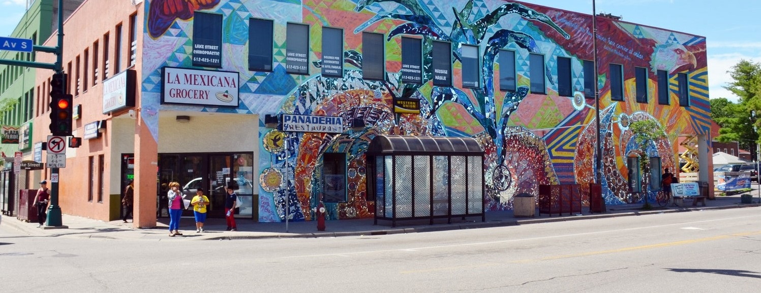 Street view of a building with colorful mural and signage