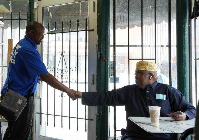 A Community Safety Ambassador shaking hands with a community member.