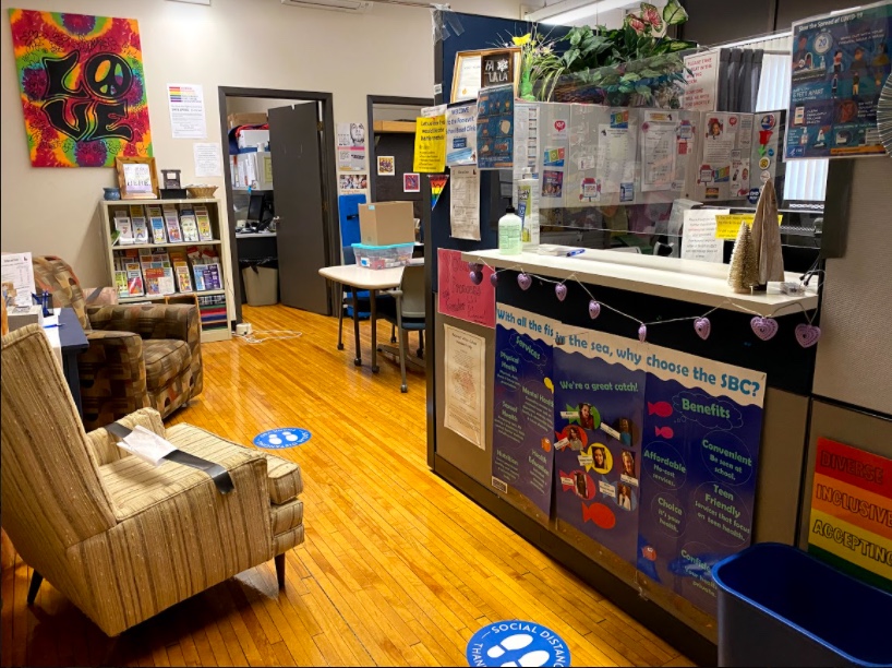 Colorful school office reception area with comfortable chairs, posters, reception desk