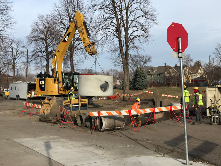 Construction workers placing piece of tunnel into street