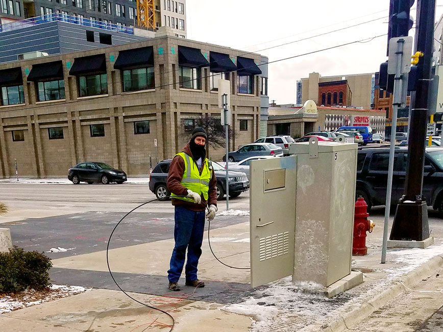 City staff person in winter adjusting traffic signal