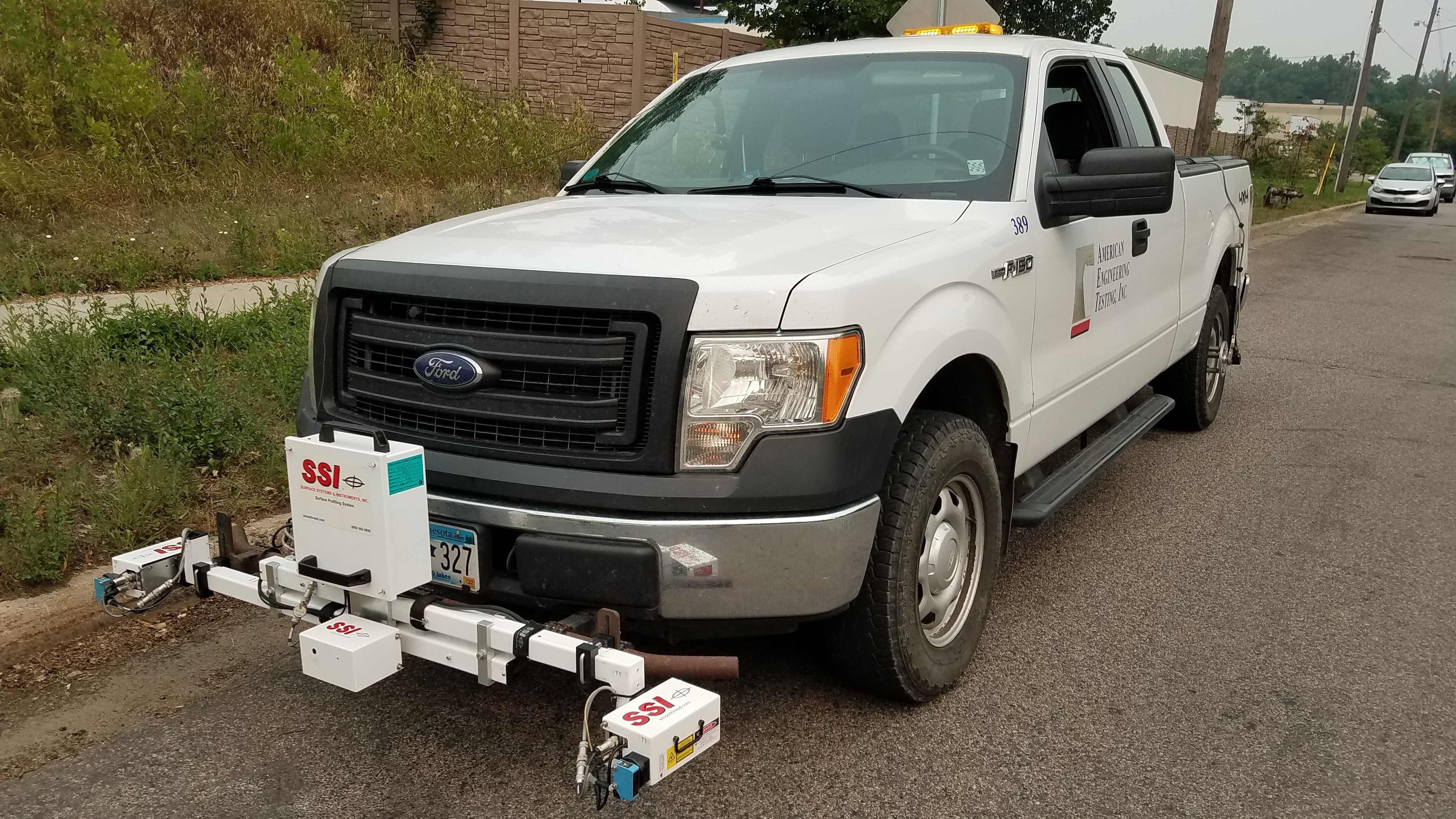 Truck with equipment on front driving along a city street