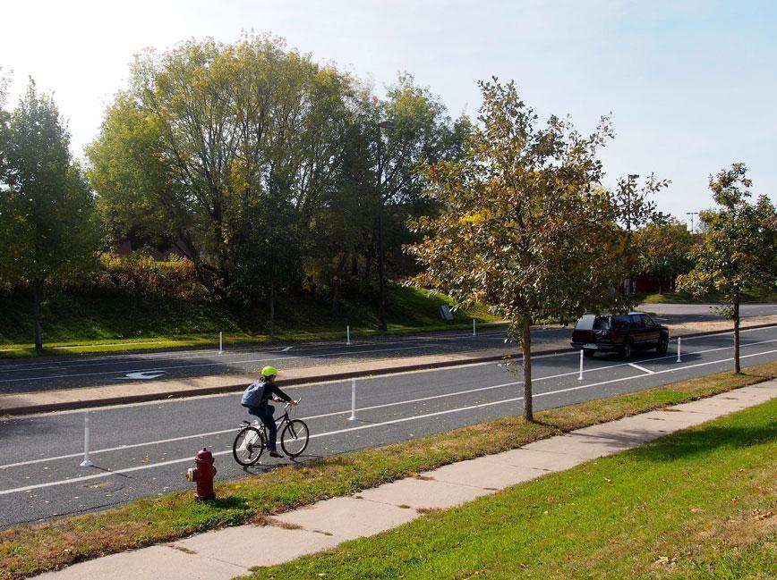 Person bicycling on protected bikeway