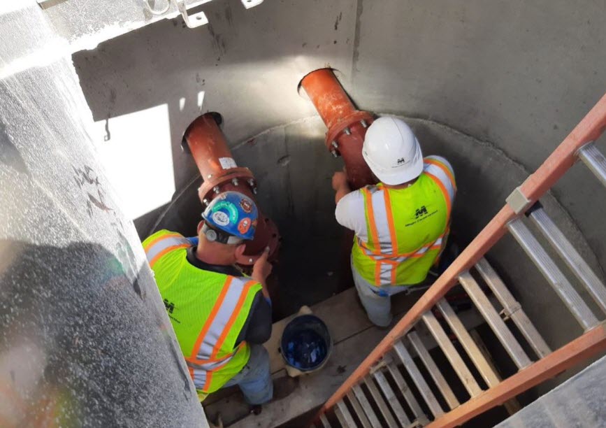 Two workers inside a manhole