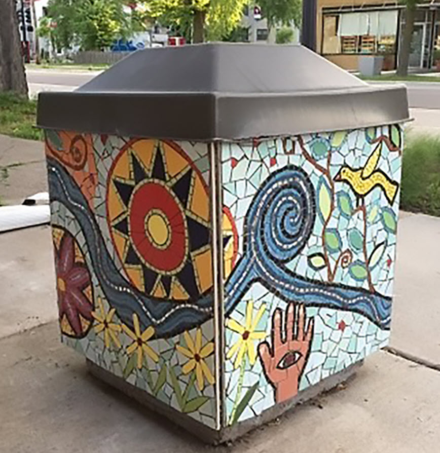 A waste container with a colorful mosaic.