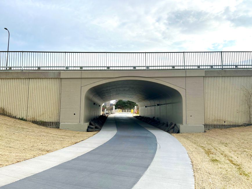 Pathway leading under a road through a tunnel.