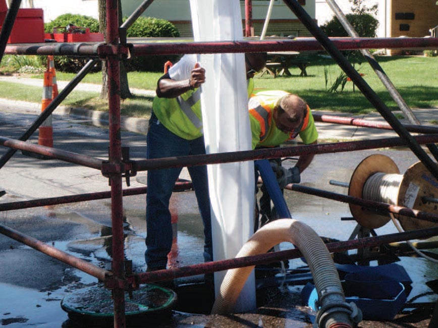 Public Works crews work to line pipe to repair existing sewer pipes