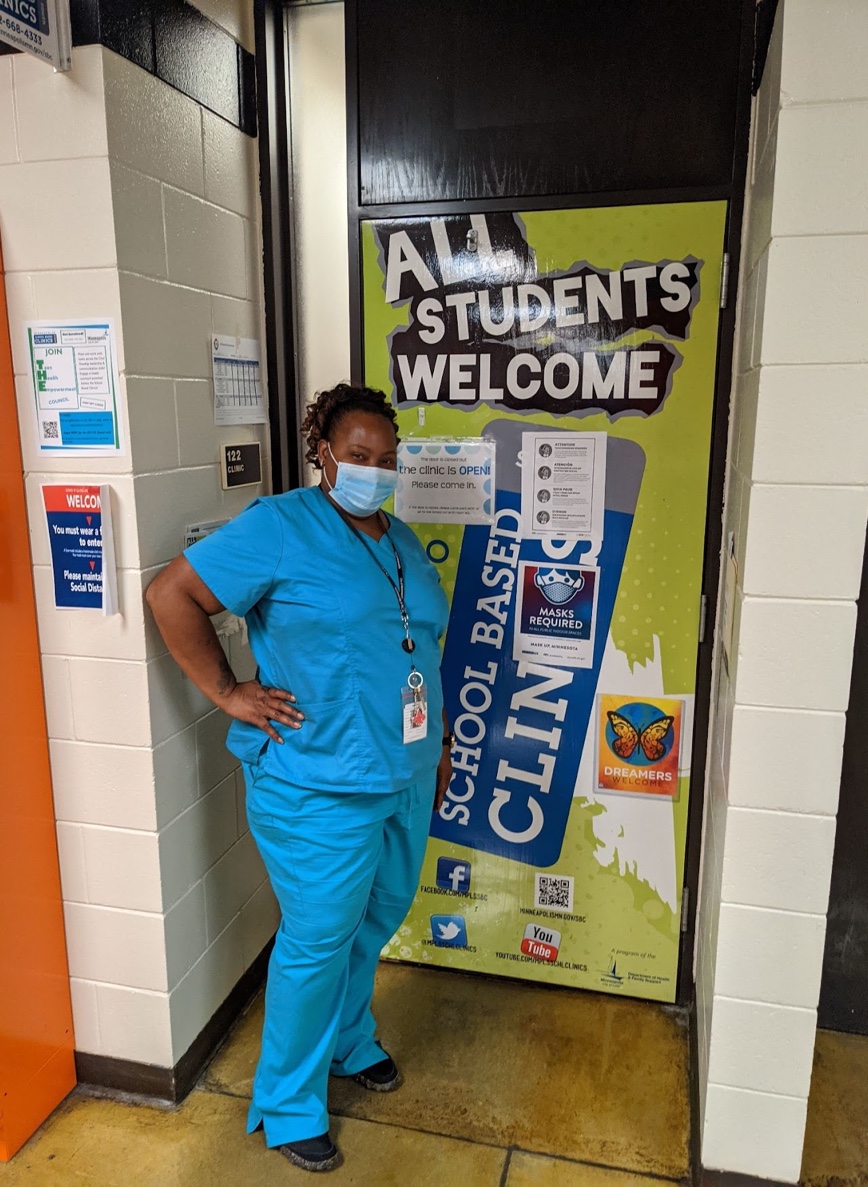 Person in scrubs at door to clinic