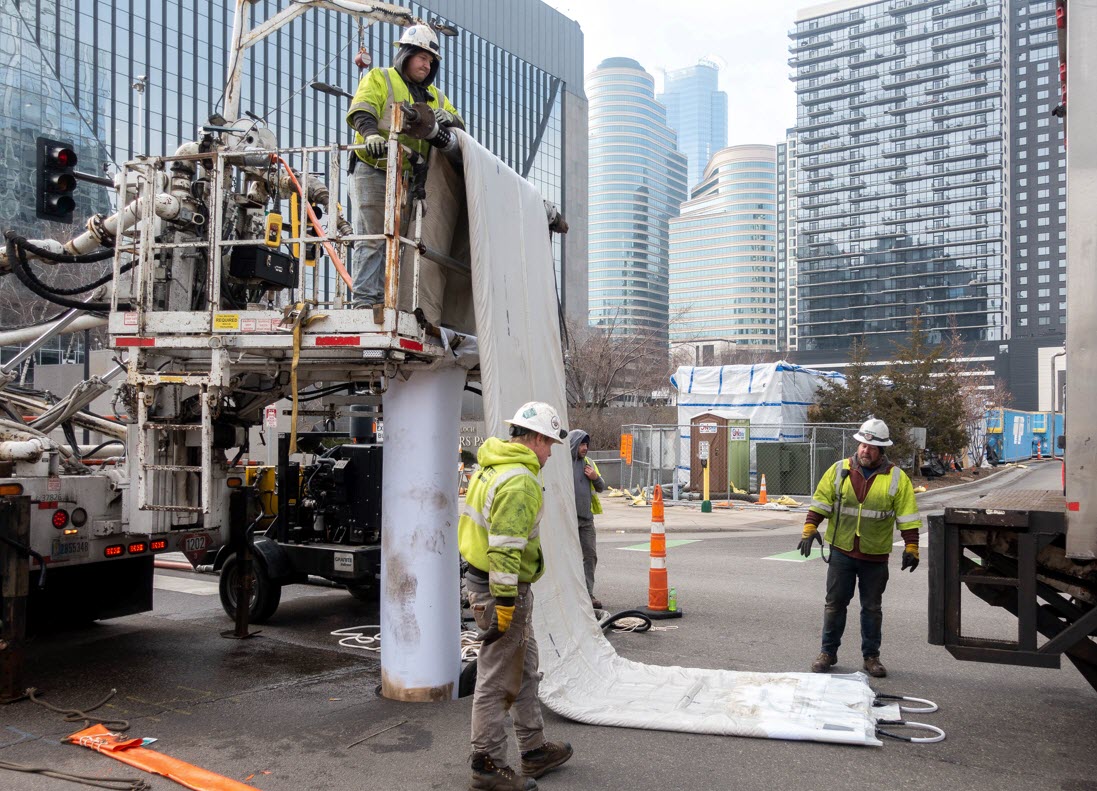 Contractor with a large pipe liner in the street.