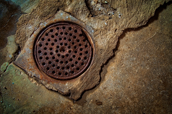 round, brown drain on cement floor