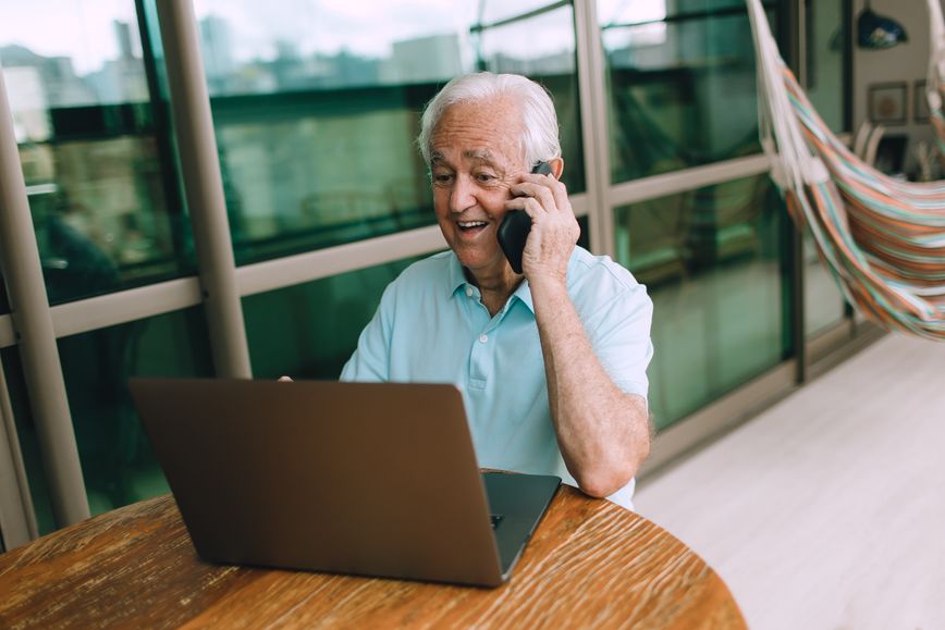 Person on a phone call while using laptop.