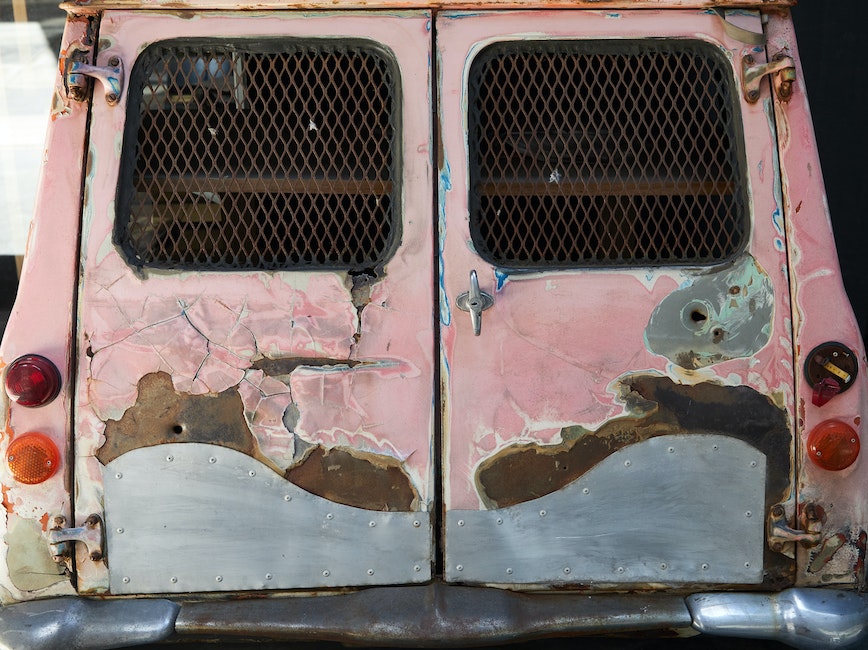 Pink truck with rust on it