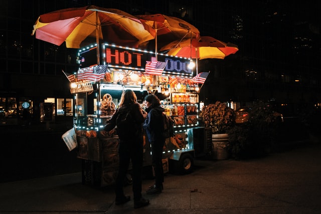 people ordering from a hot dog stand