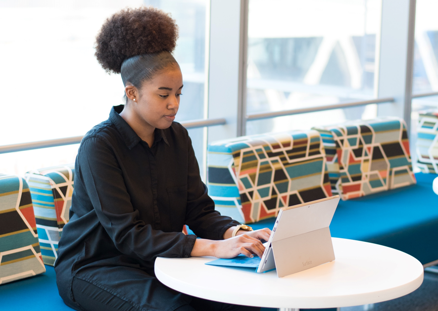 Person typing on a laptop while sitting at a table