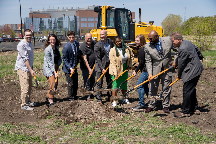 Group of people holding shovels with soil