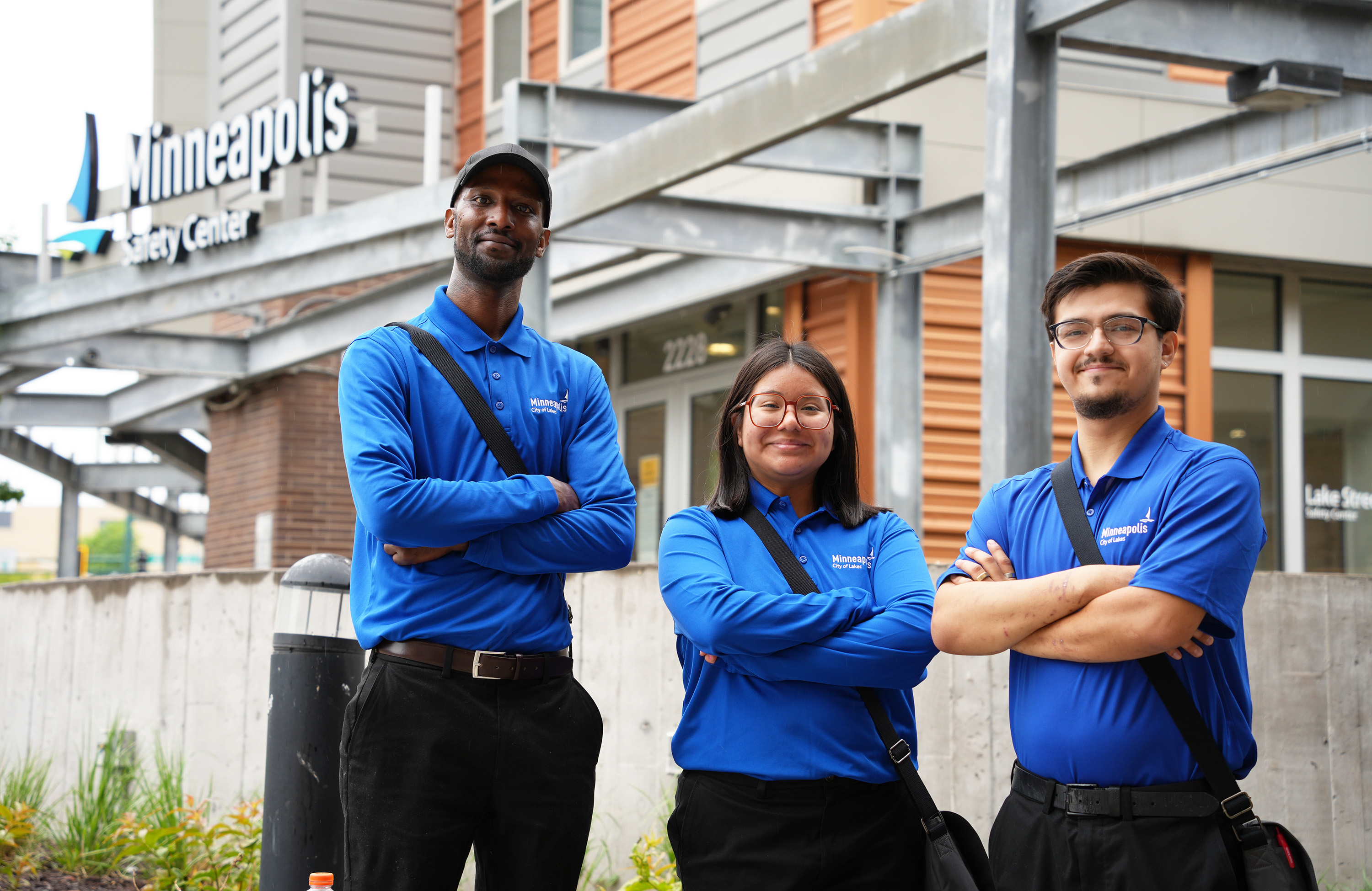 Three community safety ambassador standing in front of a safety center.