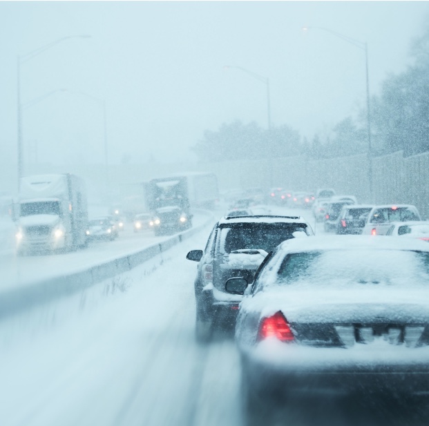 Traffic coming and going on snowy freeway during snowstorm.