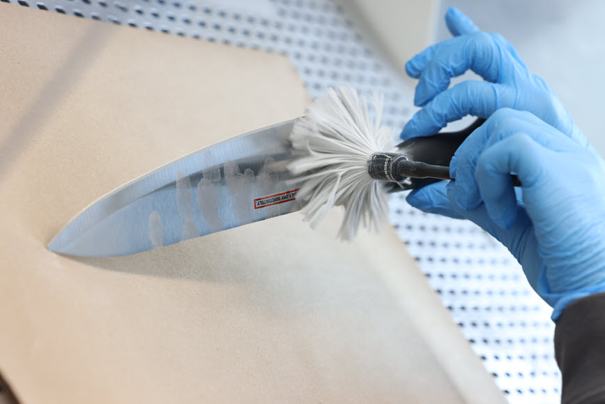 Gloved hands dusting for fingerprints on a knife Gloved hands dusting for fingerprints on a knife