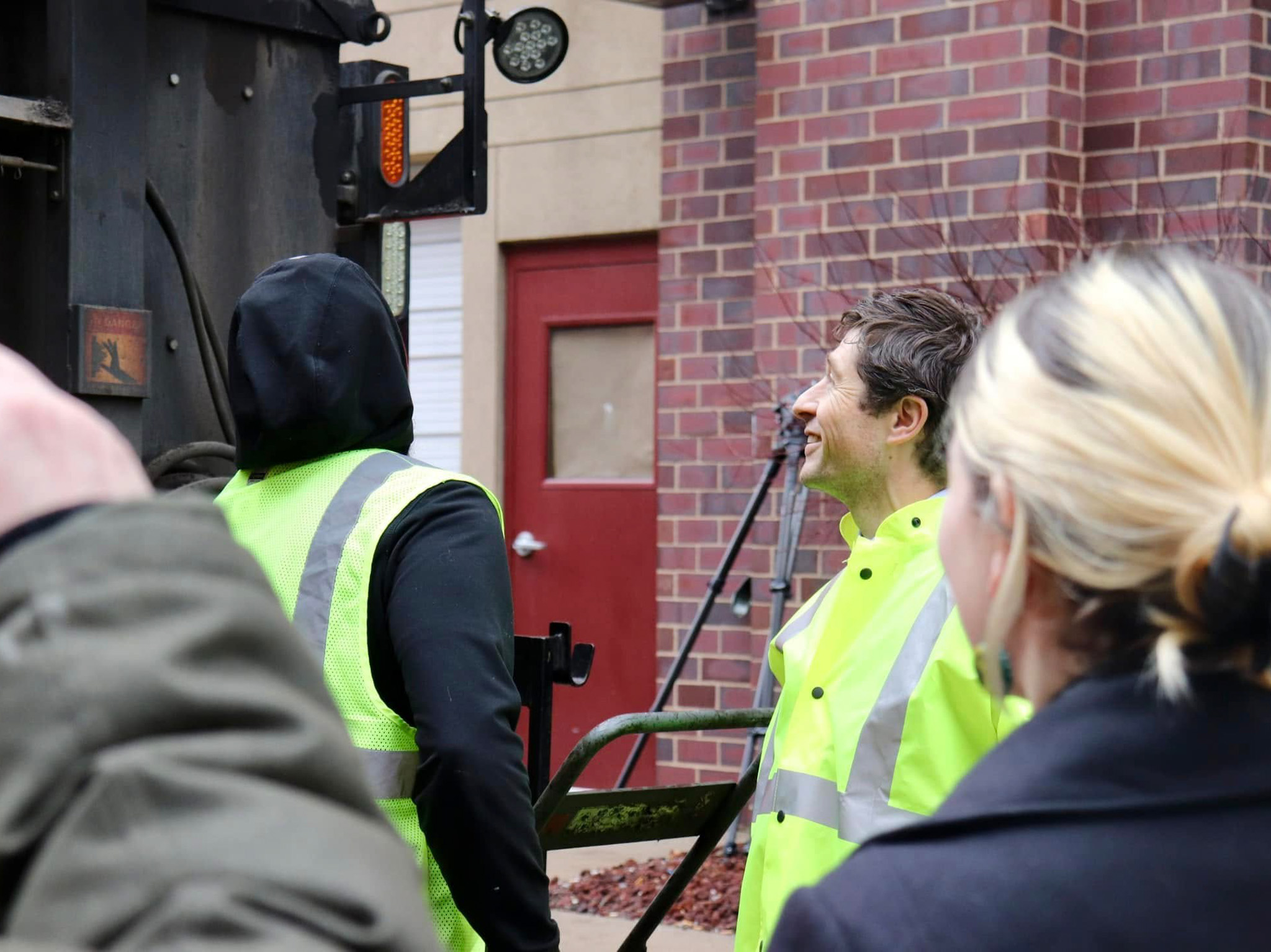 Mayor Frey in a high-visibility jacket standing with other people outside a large truck