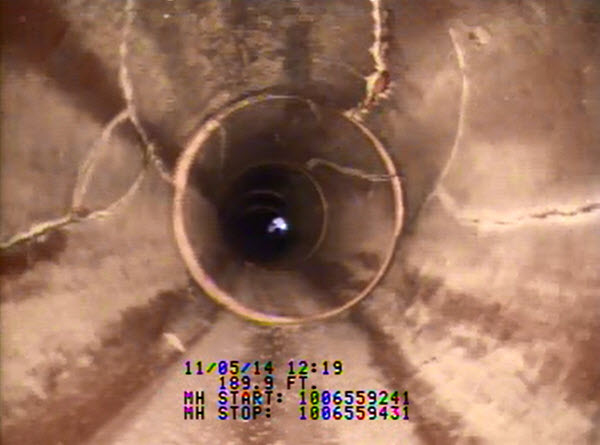 Interior view of storm pipe with cracks along the pipe's length. Interior view of storm pipe with cracks along the pipe's length.