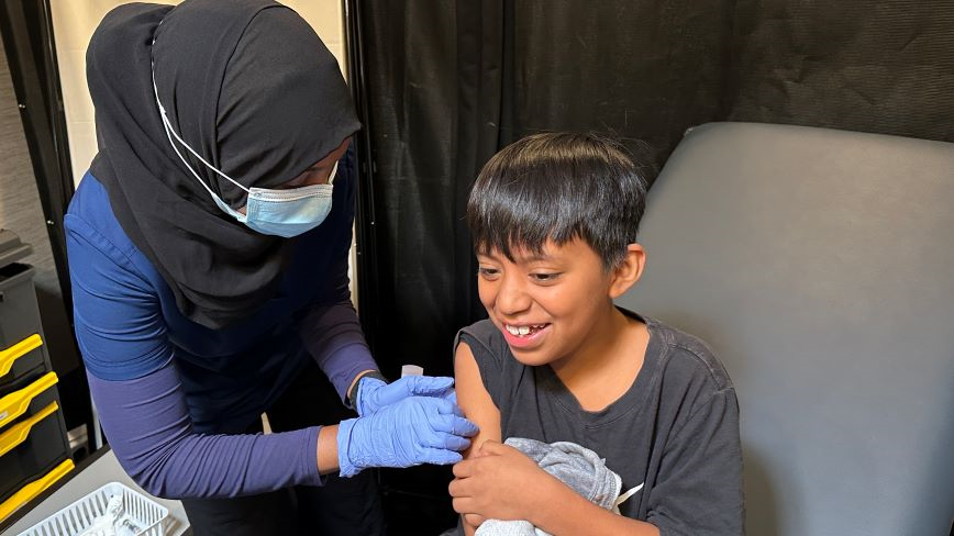 Person giving child a vaccine