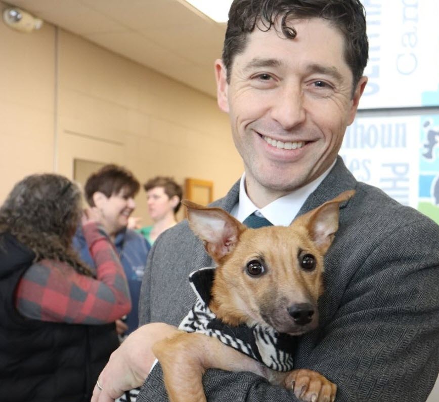 Mayor Frey holds a small dog during an event at Animal Care and Control