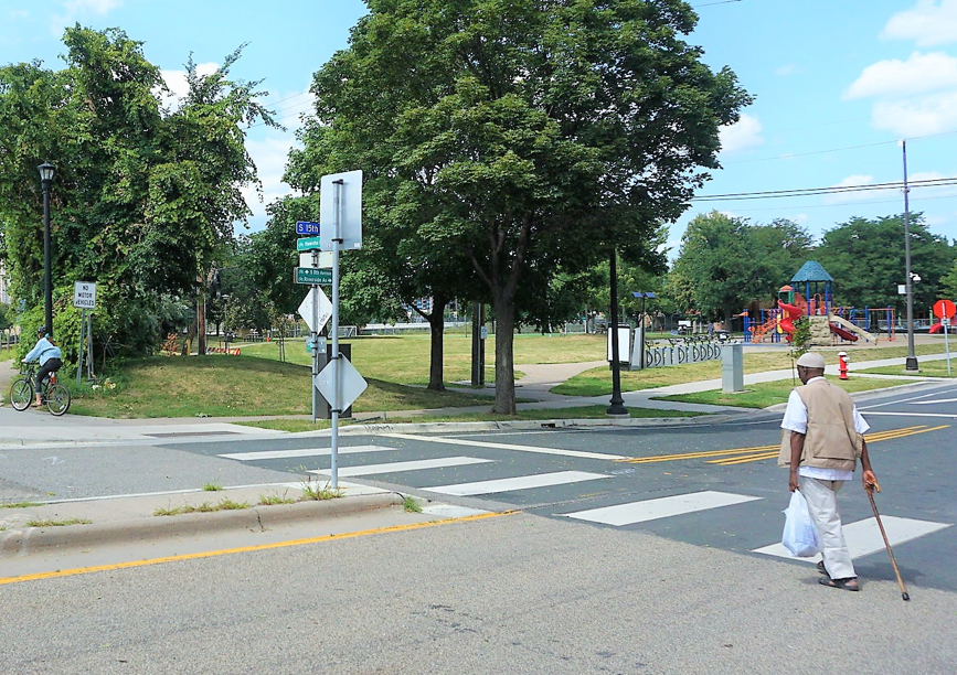 pedestrian with cane at the crosswalk near downtown