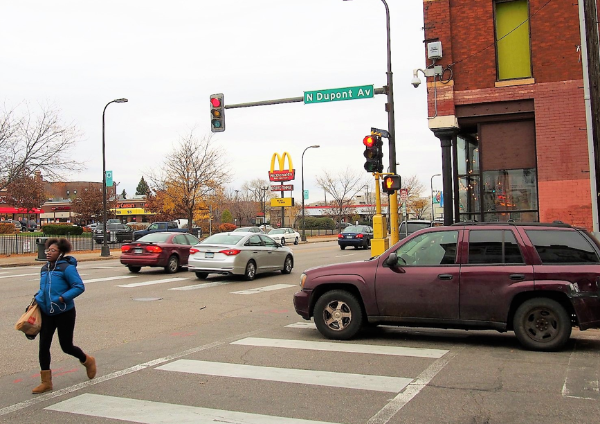 person crossing street holding bags