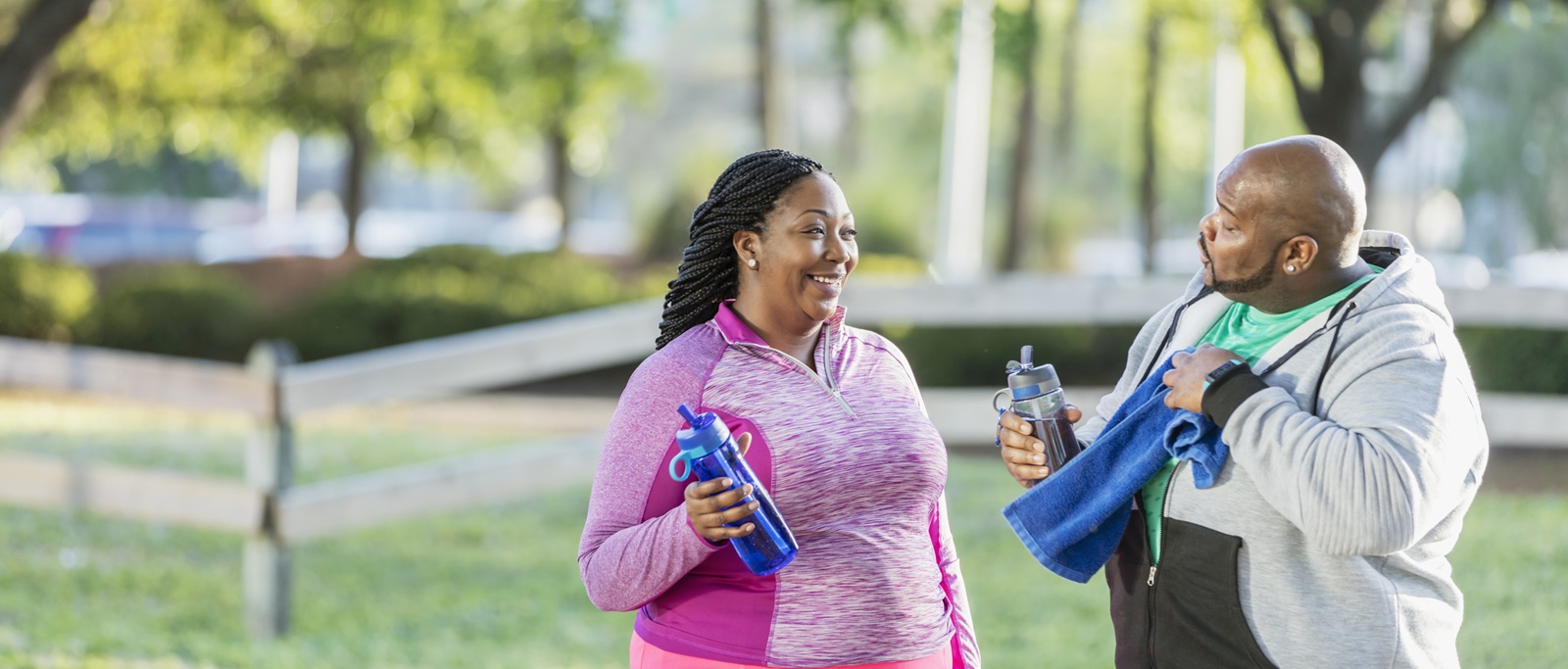 Smiling couple drinking water and exercizing together Smiling couple drinking water and exercizing together