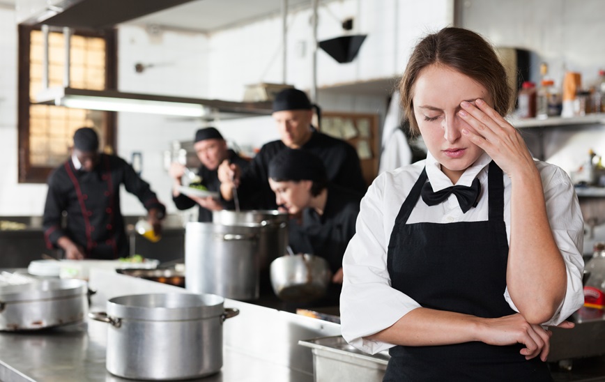 Restaurant employee with hand to head Restaurant employee with hand to head