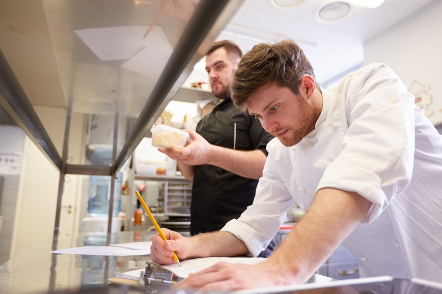 Restaurant employee looking at document Restaurant employee looking at document