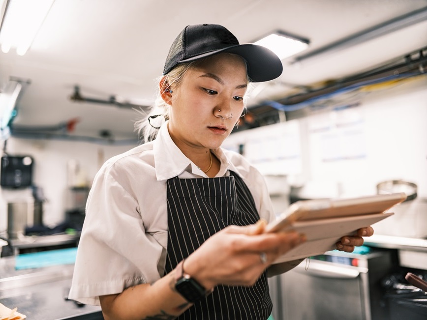 Restaurant employee looking at clipboard Restaurant employee looking at clipboard