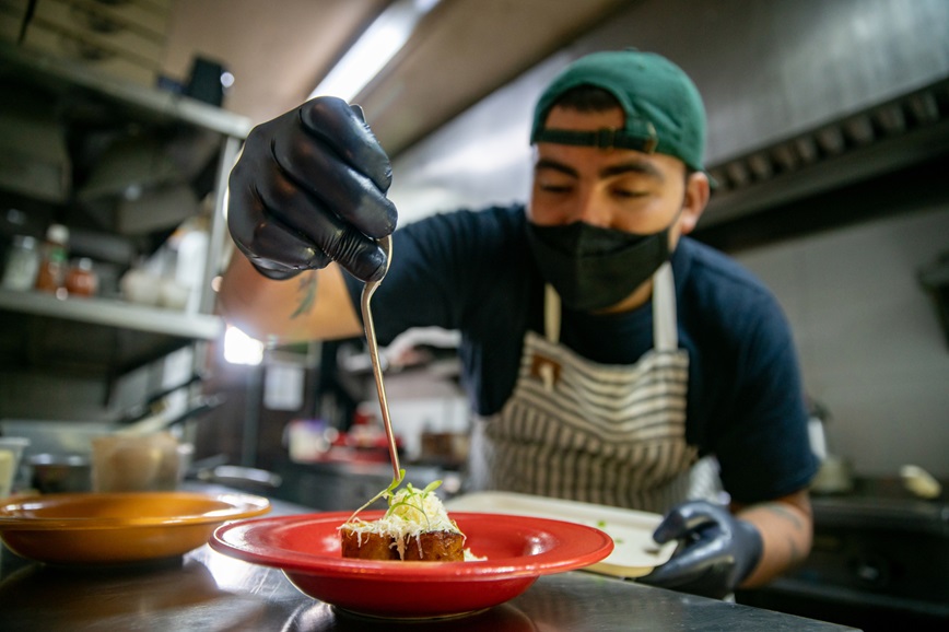 Restaurant kitchen worker checking food temperature Restaurant kitchen worker checking food temperature