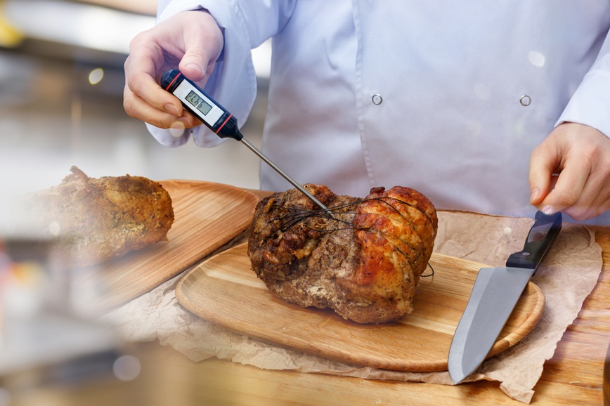 Chef checking temperature of cooked food Chef checking temperature of cooked food