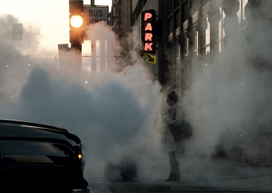 Person on sidewalk with smoke around them Person on sidewalk with smoke around them