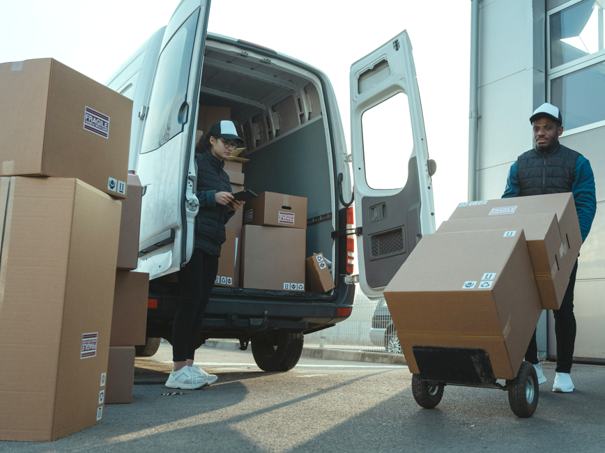 Two people unloading boxes from a delivery van Two people unloading boxes from a delivery van