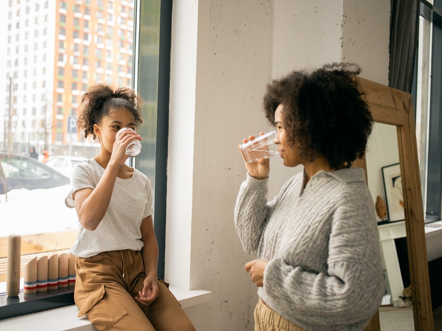 young person and adult drinking water