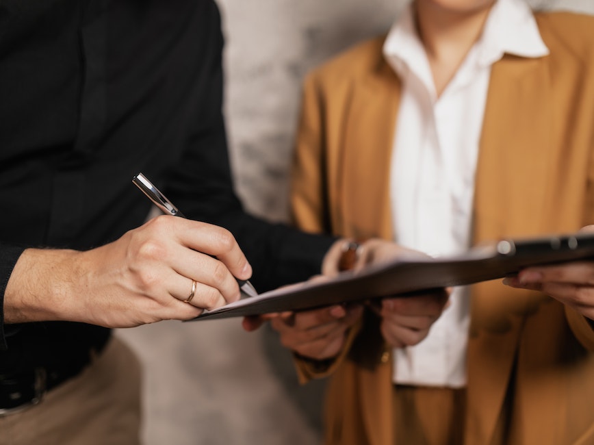 Person signing a piece of paper Person signing a piece of paper