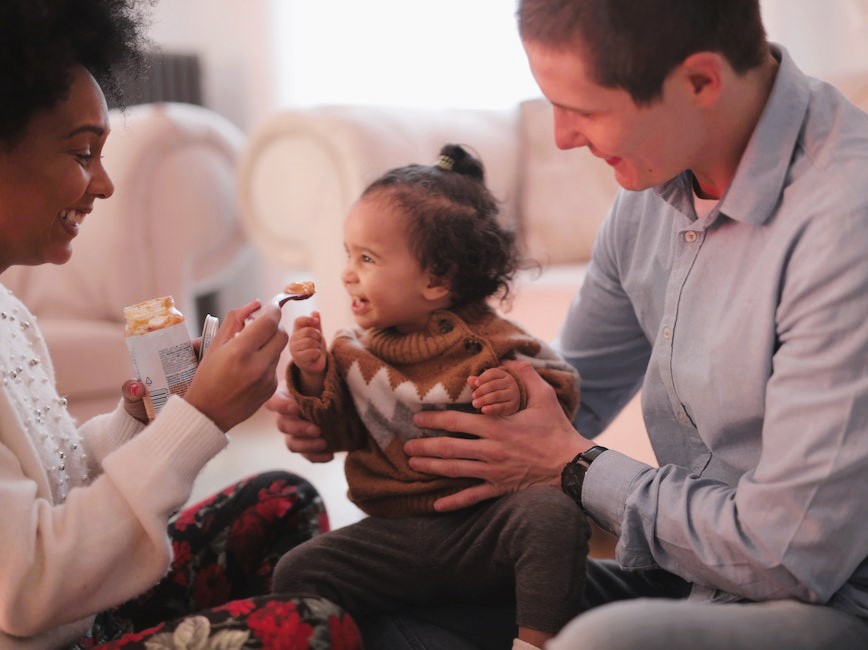 Parents feeding their young child