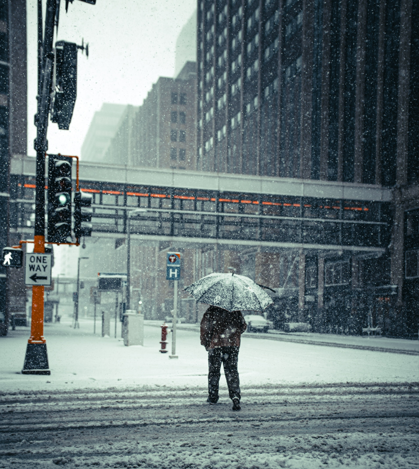 Person walking across street in snow