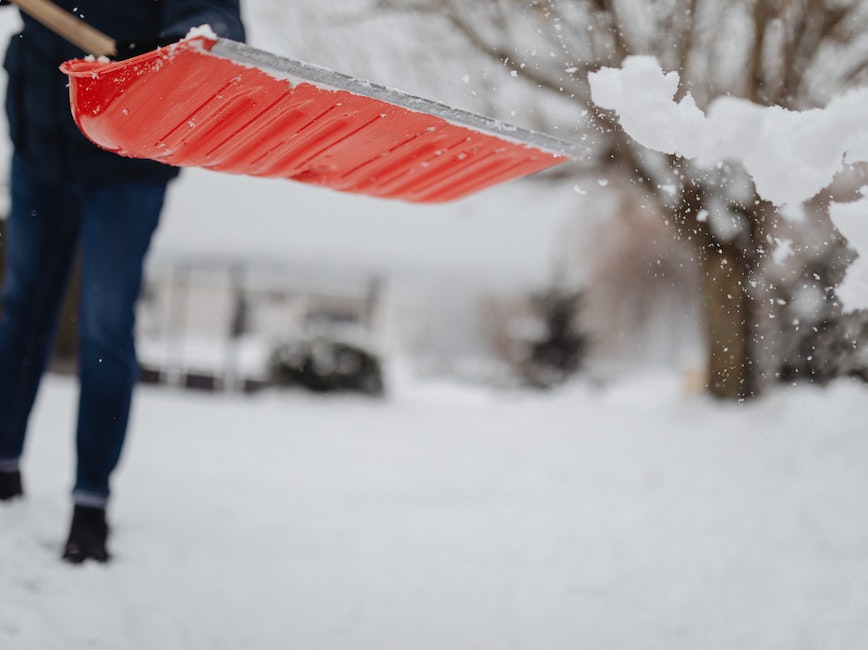 Red shovel removing snow