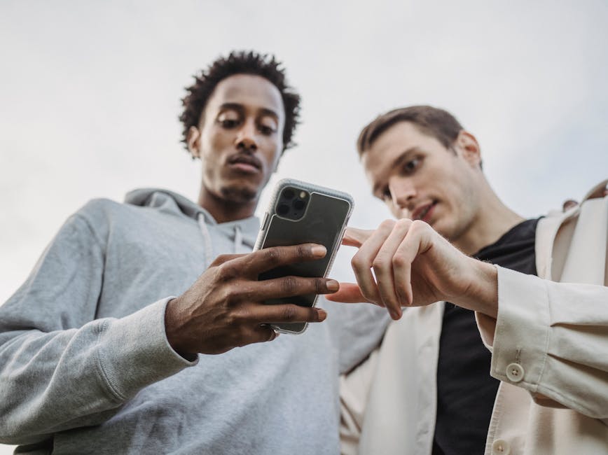 Two people staring at cell phone Two people staring at cell phone