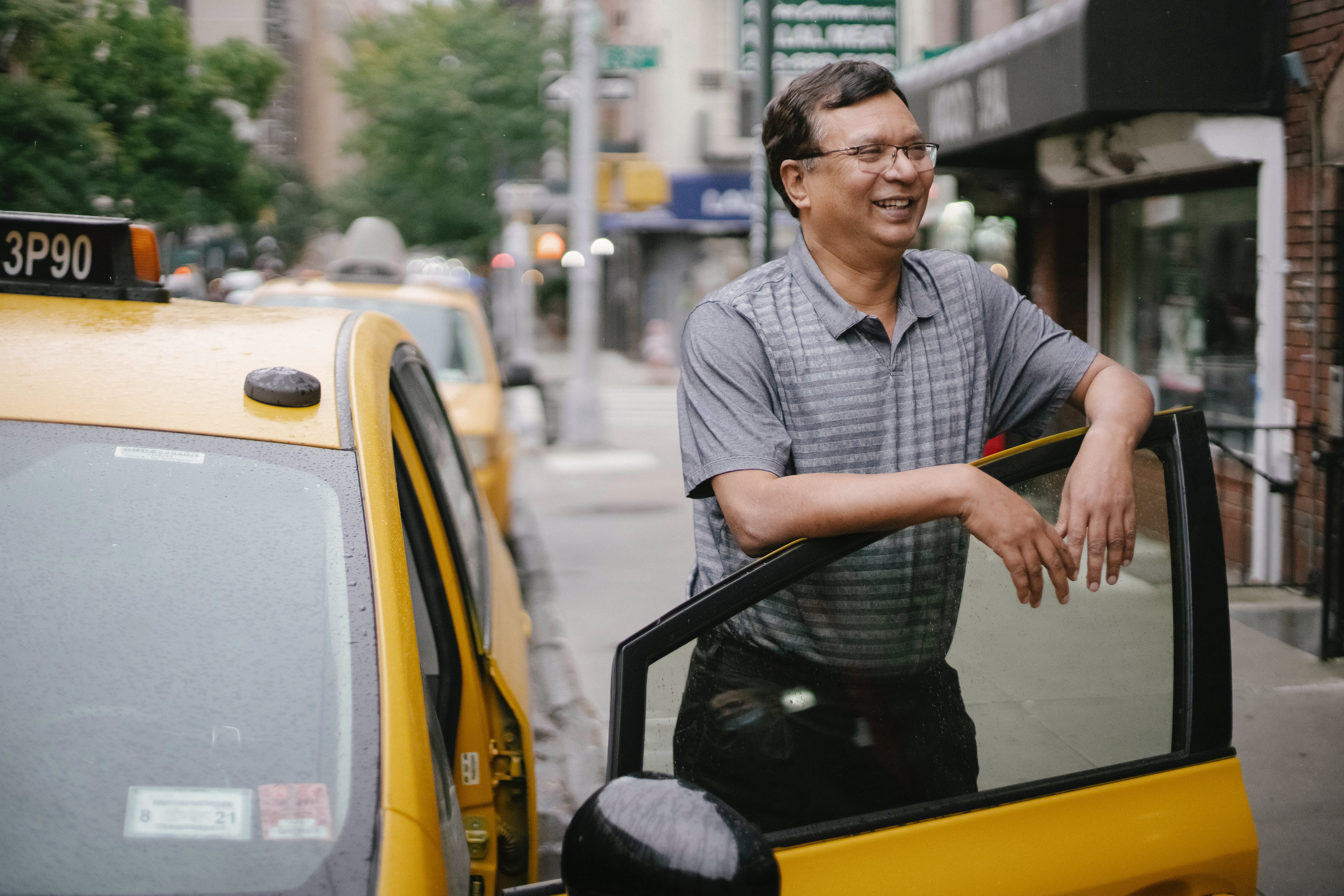 Taxi driver standing by cab