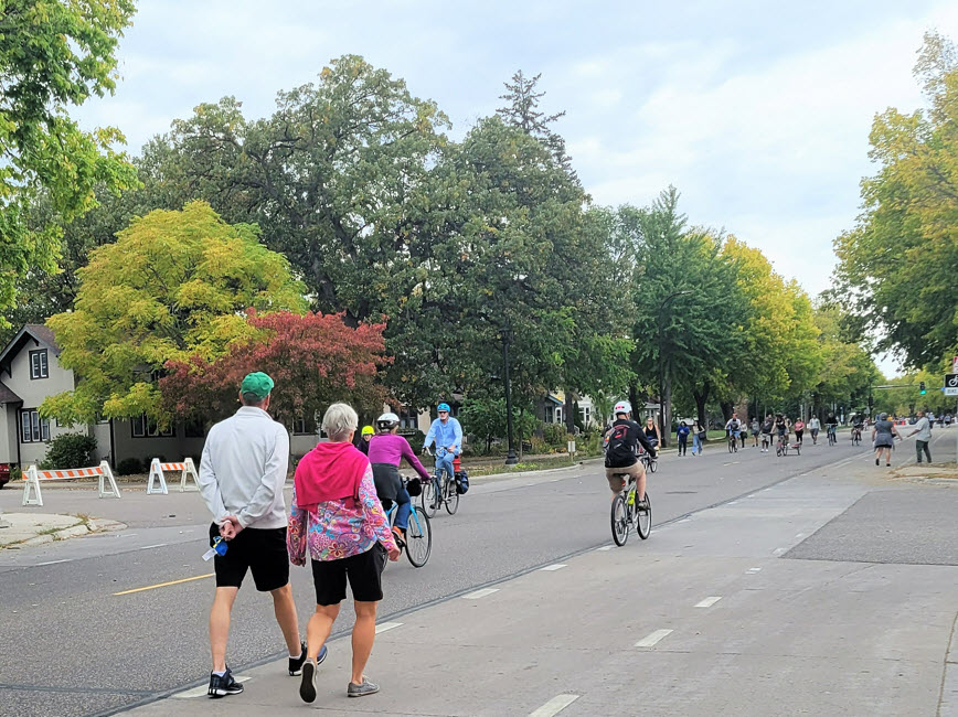 People walking and biking down the street